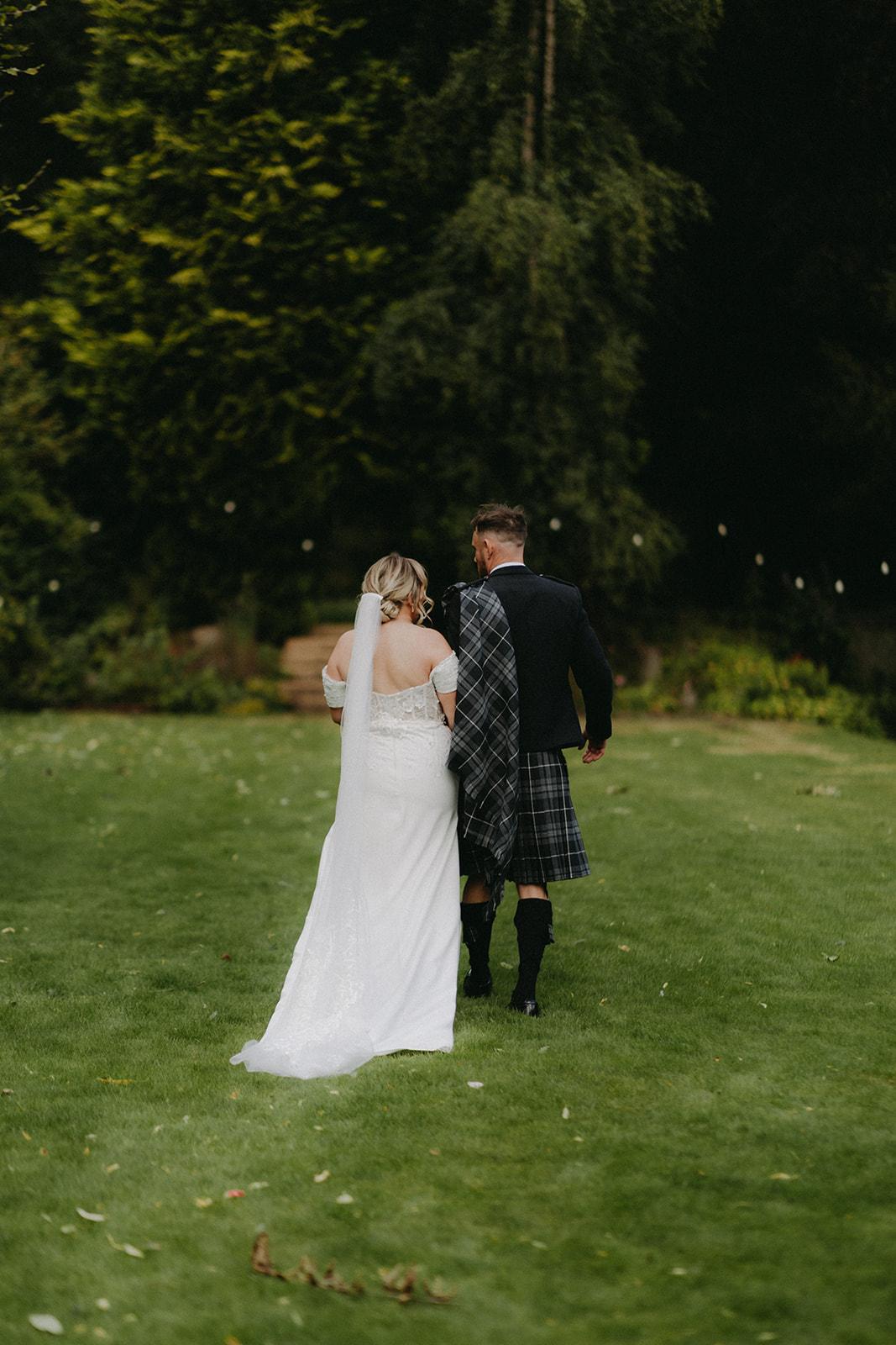 Back view of the Celtic Pearl off-the-shoulder crepe wedding dress with chapel train
