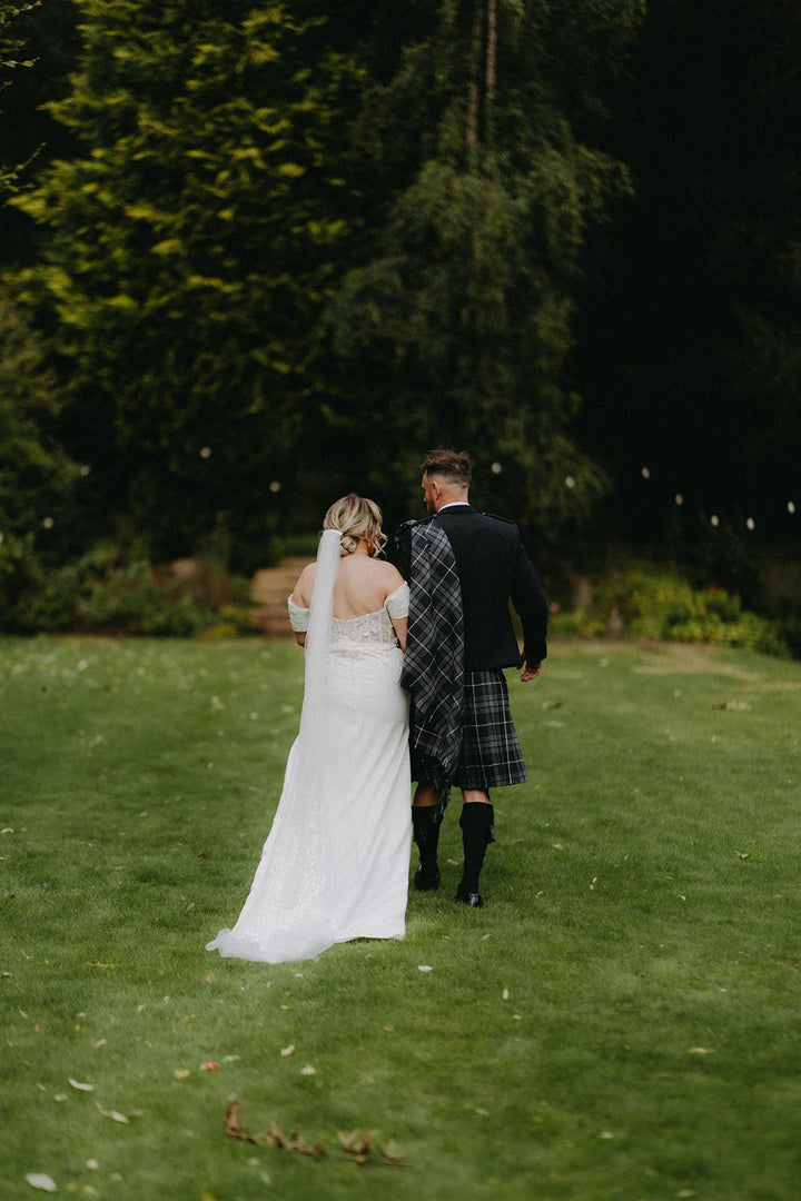 Back view of the Celtic Pearl off-the-shoulder crepe wedding dress with chapel train